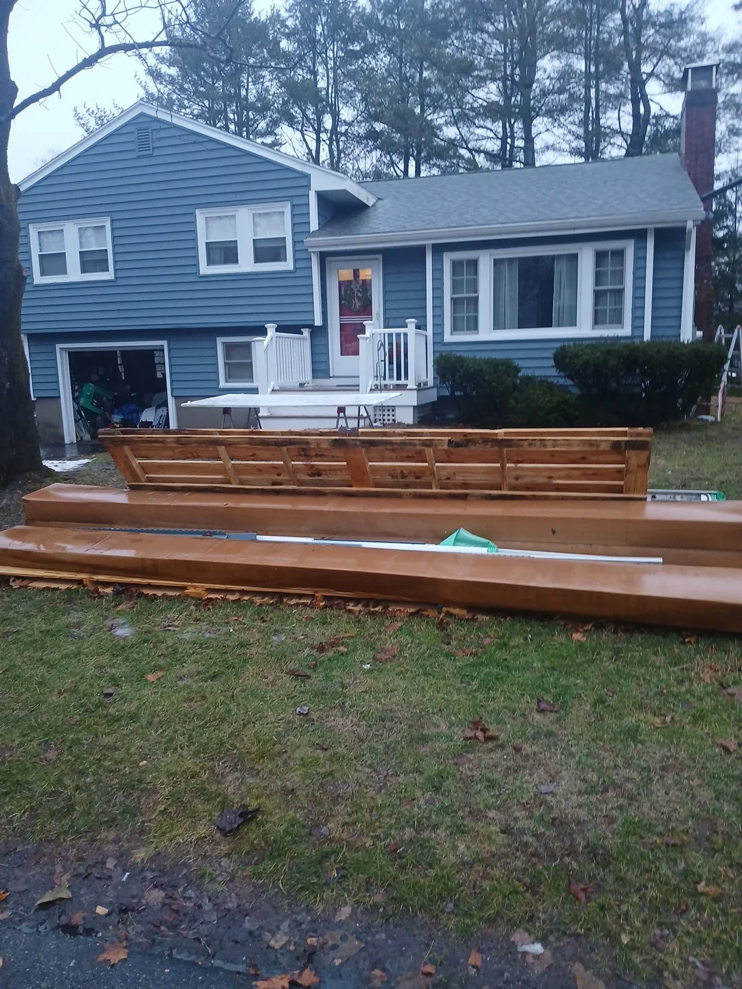 Multi-level cedar deck with bench seating in front of blue house