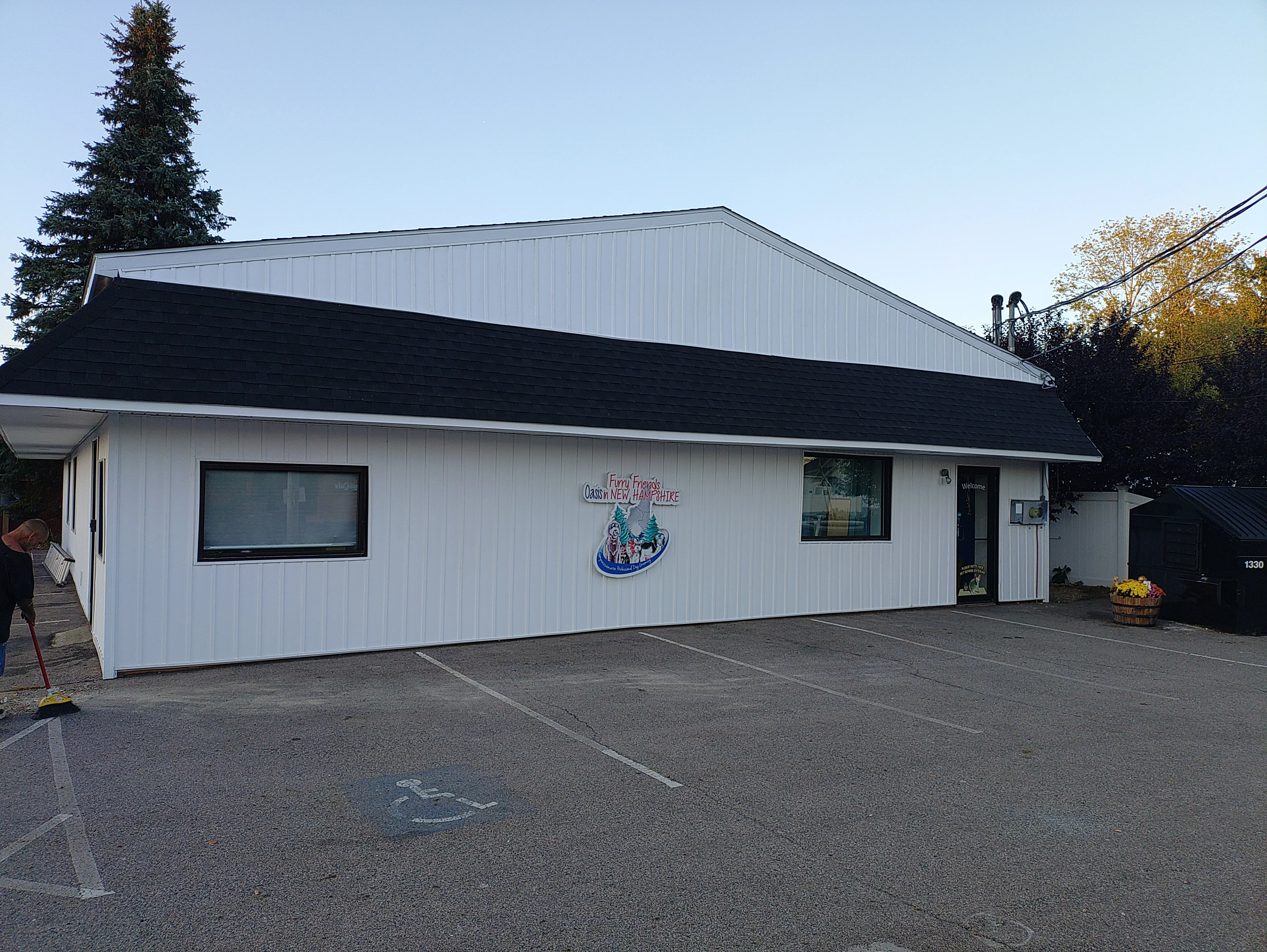 Commercial building with new light gray metal roof and black shingle lower section