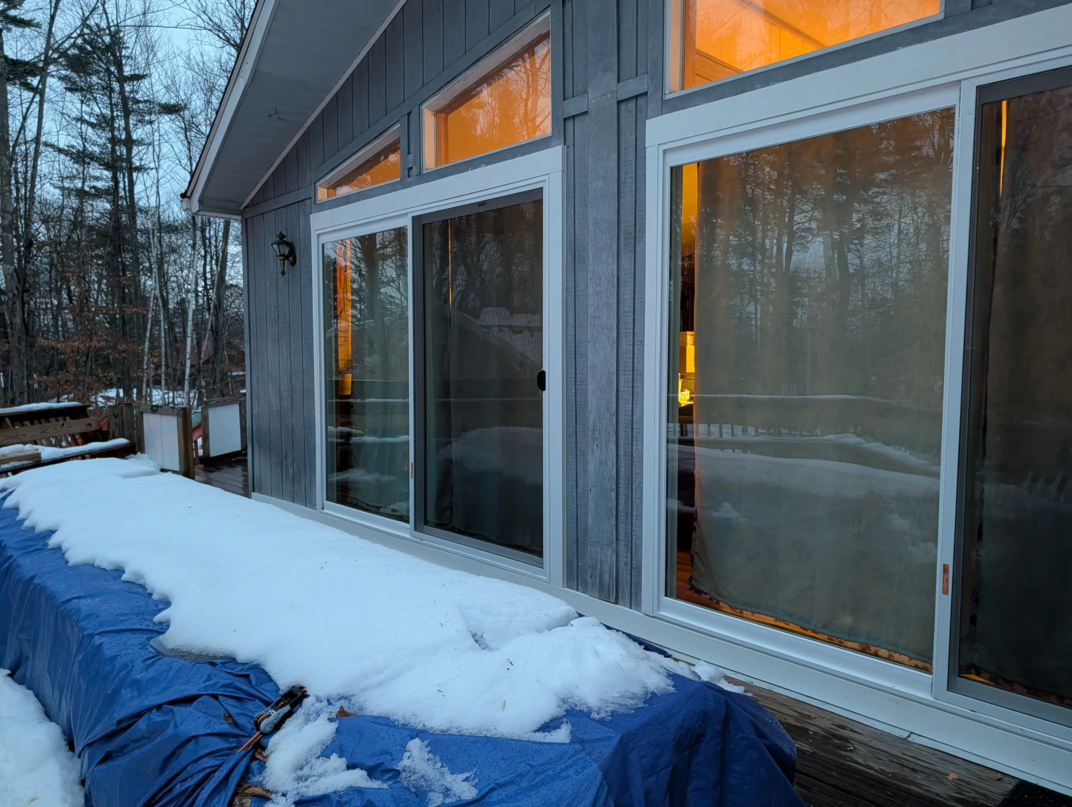 Modern aluminum-framed sliding glass doors installed on residential home exterior in winter