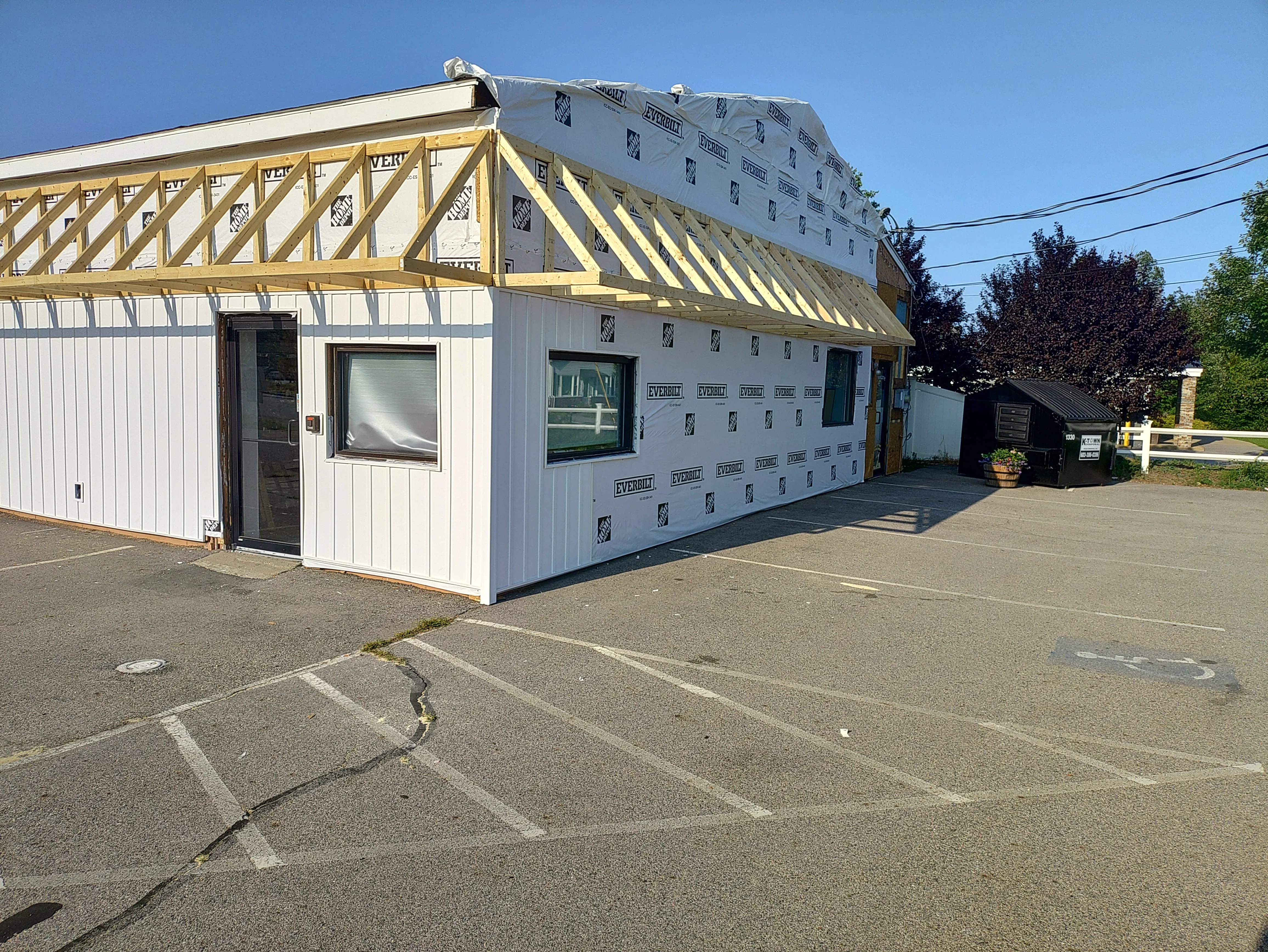 New residential roof framing with yellow trusses and white sheathing under construction