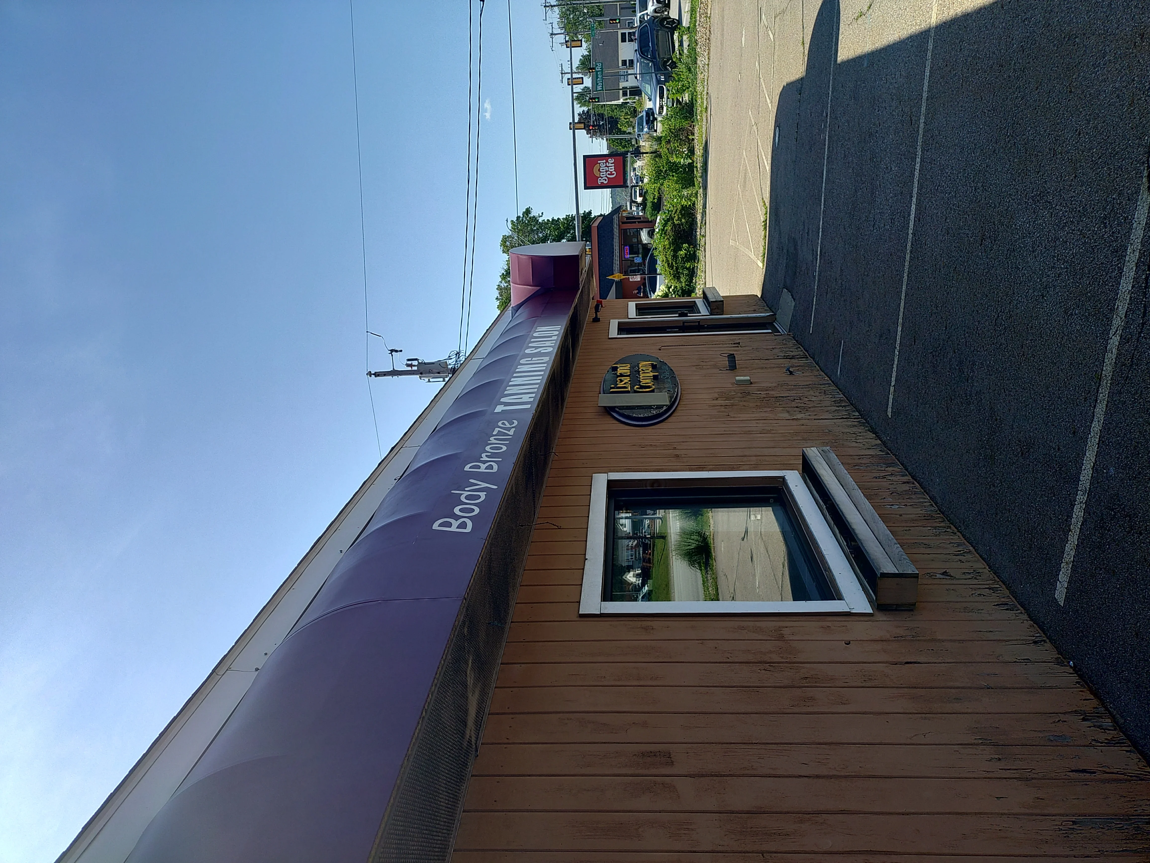 Commercial building with burgundy metal roof and wood-grain siding installation