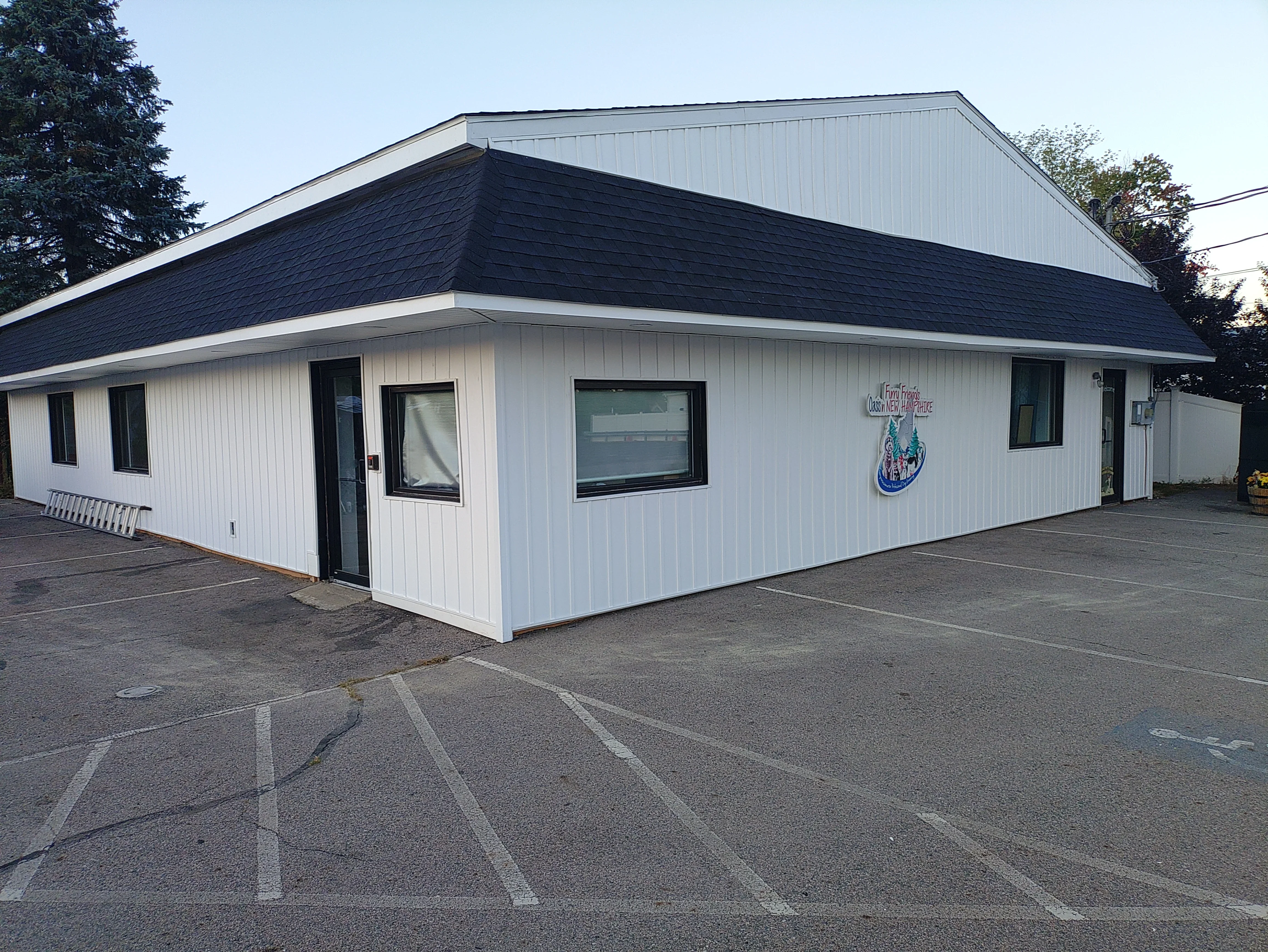 White commercial building with dark pitched roof and black-trimmed windows